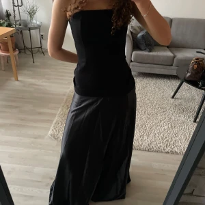 Svart axelbandslös långklänning - Svart klänning med bandå överdel, aldrig använd! Är 168 för längd referens, skulle säga att den sitter som en s! 