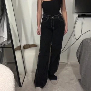 Hugo boss mid rise Bella poarch - Snygga svarta jeans från Bella Poarch’s kollektion med Hugo boss. Snygga detaljer, sitter figursytt vid midjan och med baggy där nere.  Storlek 28/32, nypris ca 1099 kr. Använd fåtal gånger 