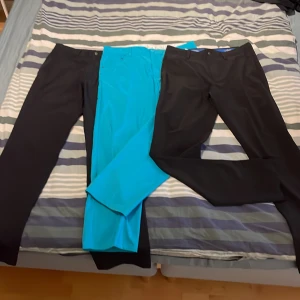 Tre par byxor i olika färger - Säljer tre par byxor: ett par svarta, ett par blå och ett par svarta till. Byxorna har en klassisk design med normal passform och är perfekta för både vardag och mer formella tillfällen. De är tillverkade i ett bekvämt material som ger en stilren look. Svart är från callaway och blå från puma. Buda på går att köp styckvis.