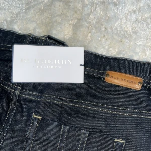 Svarta jeansbyxor från Burberry - Snygga svarta jeansbyxor från Burberry med klassisk design. Byxorna har en midwaist passform och är tillverkade i ett slitstarkt material. Perfekta för en stilren look. Är ej använda
