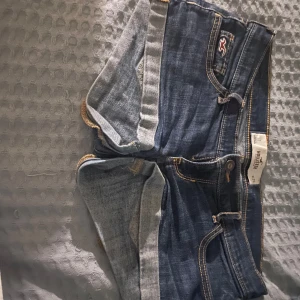 Blå jeansshorts från Hollister - Snygga blå jeansshorts från Hollister med klassisk femficksdesign och kontrastsömmar. Perfekta för en avslappnad sommarlook. De har en lågmidjad passform och är tillverkade i slitstarkt denim.