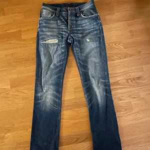 Slitna Nudie Jeans - Säljer ett par snygga blå jeans från Nudie med slitningar. Hör gärna av er vid eventuella frågor eller fler bilder😊👍. Skickas kort innom sluten affär .