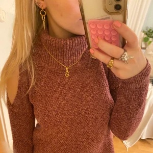 Vinröd stickad polotröja - Säljer en vinröd stickad tröja med trendiga cut-out detaljer på axlarna. 