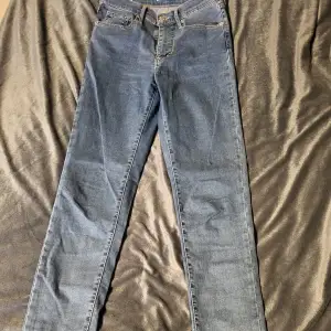 Säljer ett par blå Mile High Super Skinny jeans från Levi's. De är högmidjade och har en tight passform. Perfekta för en stilren look.