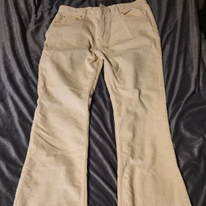 Beige manchesterbyxor från Perfect Jeans - Snygga beige manchesterbyxor från Perfect Jeans. Byxorna har en klassisk bootcut-stil och är perfekta för en avslappnad look. De har fickor både fram och bak samt en bekväm passform.