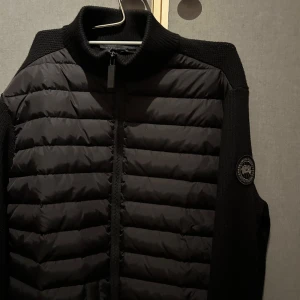 Canada Goose Hybrid Jacka - Säljer min canada goose hybrid då den inte används längre. Varit hos skräddaren se bild 3, annars fint skick! Storlek L men passar M! 