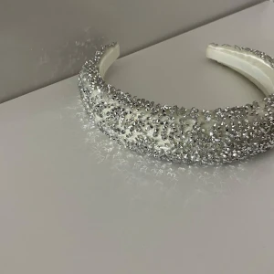 Glittrigt diadem i silver - Snyggt diadem täckt med glittrande silverpaljetter. Perfekt för att ge en extra touch till din outfit. Diademet har en bekväm passform och är idealiskt för festliga tillfällen.