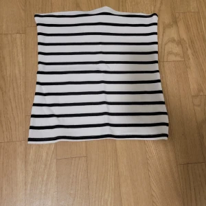 Randig tubtopp - Säljer en stilren randig tubtopp i svart och vit. Aldrig använd då den inte passade mig.