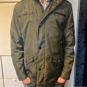 Feild jacket från Riley - Snygg grön jacka från Riley som bara är använd 1 gång pga att den är i fel storkek. Nypris låg på 1600kr om jag inte minns fel. Jackan har flera praktiska fickor med dragkedjor och snygga knappar och en hög krage som är riktigt snygg. Perfekt för vardagar och finare tilfällen