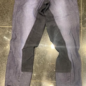 Mörkblå ridbyxor från CRW - Snygga mörkblå ridbyxor från CRW med förstärkta partier i svart. Byxorna har en klassisk design med fickor bak och en bekväm passform. Perfekt för ridning. Köpta på Hööks för 4 år sedan