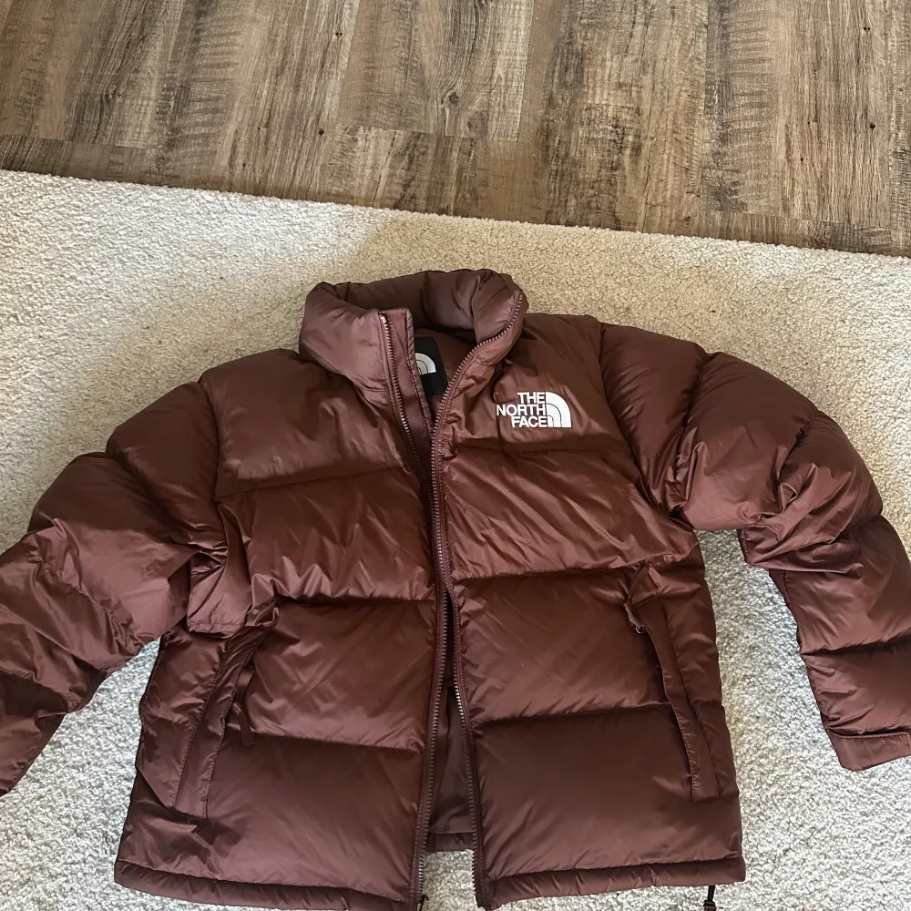 Intressekoll på brun pufferjacka från The North Face i modellen W 1996 RTRO NPTS JKT. Säljer pga använt max 5 ggr och de va en dyr jacka, så den är som helt ny. Storlek L men känns mer som en M, nypris 3700. Säljer för 2999 eftersom den är som helt ny. Takit.