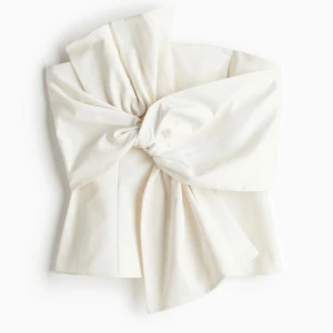 Svart off-shoulder topp med rosett - Snygg axelbandslös topp med en stor rosett framtill. Toppen är i SVART. Säljer då den var för liten, därav inga bilder med tröjan på💖