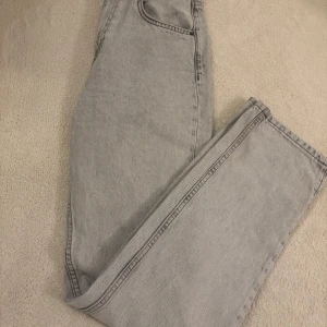 Grå jeans från Zara - Snygga grå jeans från Zara med hög midja och klassisk femficksdesign. Perfekta för en avslappnad stil med en rak passform som ger en tidlös look.