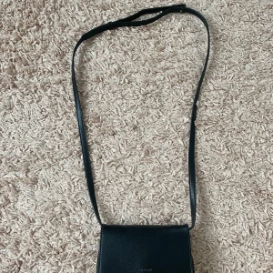 Jättefin svart liten väska med axelband  - Inga defekter, i jättebra skick och använd enbart en gång💕
