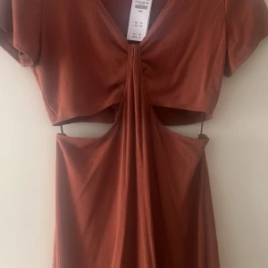 Klänning - Helt oanvänd brun klänning med öppen rygg till mage. Storlek L från Abercrombie & Fitch. Köpte för 65 euro. Prislapp kvar.