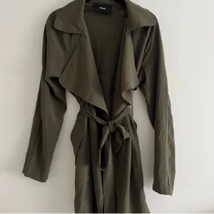 Kort Tunn Grön Kappa  - Säljer en kappa som var för kort på mig, den är i nyttskick, tunt material (typ tyg material) i storlek S
