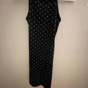 Svart klänning med silver detaljer från H&M. - Klänningen är i storlek xs men är stretchig. Säljer pga för liten, använd endast en gång på nyår. 