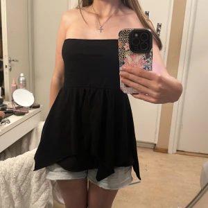 Axelbandslös volang topp - Oanvänd! Den är 37,5 cm i bysten rakt över. Jag har 80cm i bysten och den sitter okej på mig men den åker lätt ner, så rekommenderar om man har lite större. Den kan även användas som kjol, dock inte gjord för det!💗 Skriv vid frågor!