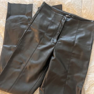 Skinnbyxor från Ginatricot  - Skinnbyxor från Ginatricot i storleken small. Den har dragkedja samt två knappar på framsidan. En kort öppning på slutet på framsidan. 