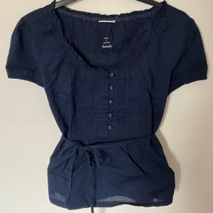 Marinblå blus - Marinblå blus som man kan knyta där bak eller fram. Jättesöta detaljer som knappar och sömmar 💕