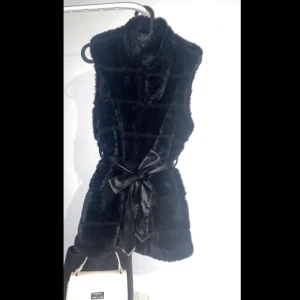 Pälsväst - Pälsväst i fint skick från New yorker-AMISU storlek 34 med avtagbart knytbälte och knäppning som man kan välja då det går lite längre samt med fickor.   Hör av er vid intresse!  Mvh 