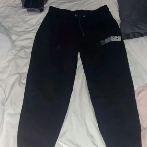 Svarta mjukisbyxor från Goodrich - Säljer ett par svarta mjukisbyxor från Hoodrich i storlek M. De är superbekväma och perfekta för chill dagar hemma eller en snabb tur till affären. Byxorna har en elastisk midja med snörning för bästa passform.