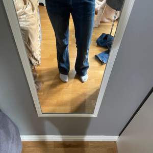 Säljer ett par mörkblå jeans i bra skick. De har en klassisk bootcut-stil och är lågmidjade. Perfekta för en avslappnad look!