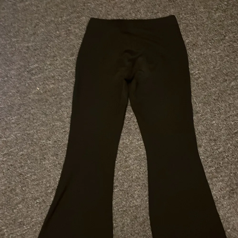 Snygga svarta bootcut byxor med hög midja. Perfekta för en stilren look och passar till många olika tillfällen. Byxorna har en klassisk design och är både bekväma och trendiga.. Farkut & Housut.