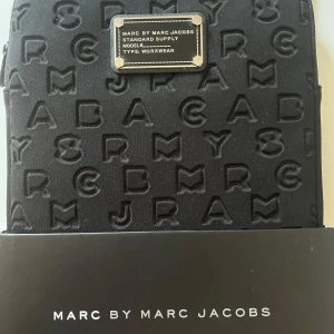 Svart ipad/datorfodral från Marc Jacobs - Snyggt och klassiskt svart fodral från Marc Jacobs, som tyvärr är lite dammigt på bilderna. Säljer då det är mindre än jag trodde, måtten står på sista bilden. Perfekt för att hålla din mindre ipad/dator repfri! 🫶🪷 Nyskick och kostade 58$, säljer för 230!