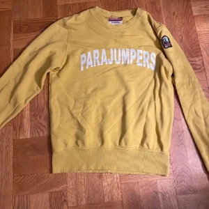 Gul tröja från Parajumpers - Kan gå ner i pris vid snabb affär. Säljer en gul tröja från Parajumpers med vit text på bröstet. 