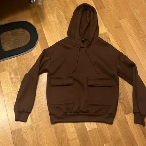Brun hoodie från Shein - Säljer en brun hoodie från Shein med praktiska fickor framtill. Den har en klassisk huva med dragsko och långa ärmar. Perfekt för en avslappnad stil. 🧡