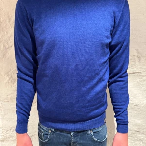 Blå tröja från Jacob Cohën - Snygg blå tröja från Jacob Cohën med rund hals och långa ärmar. Perfekt för en stilren look. Tröjan har en enkel design och är tillverkad i ett mjukt material som ger en bekväm passform. Killen på bilden är 185cm! Var inte rädd att höra av dig vid några frågor eller funderingar! Pris kan som alltid diskuteras!😉🤩