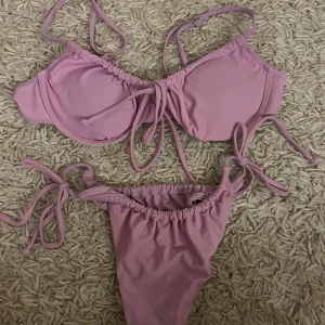 Lila bikini med knytband - Snygg lila bikini med knytband både på toppen och trosorna. Perfekt för en dag vid stranden eller poolen. Den har en enkel och stilren design som ger en fräsch look. Fraktar endast varan. Och köparen betalar frakten. Priset som visas är vad den säljs för🙏🫶