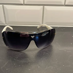 Svarta solglasögon med vita skalmar - .Köpta i Spanien, så inte äkta!  Väl använda då, se bild på slitage på båge.