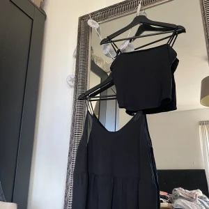 Svart klänning med matchande topp - Säljer en stilren svart linne med smala axelband och en matchande kort linne topp. Perfekt för en chic look. Ena har en luftig passform och ändra linnet är gjord i ett mjukt material. Linnet längst ned är i storlek M och är från Gina tricot och de korta linnet som är basic är från h&m i storlek s eller xs. Lite slitage i sömarna på de linnet längst upp medans linnet längst ned är i väldigt bra skick och snygg😻