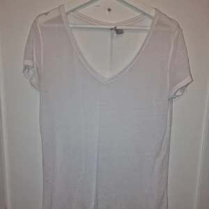 Vit v-ringad t-shirt från Only - Säljer en stilren vit t-shirt från Only med v-ringad hals. Perfekt basplagg för alla tillfällen. Kortärmad och i mjukt material för skön komfort till sommaren, oversize modell.