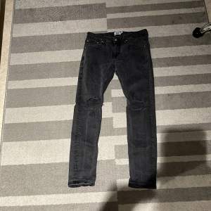 Snygga svarta jeansbyxor från 157 i storlek M. Byxorna har en slim passform med slitna detaljer vid knäna. Perfekta för en trendig look. Använda bara några gånger