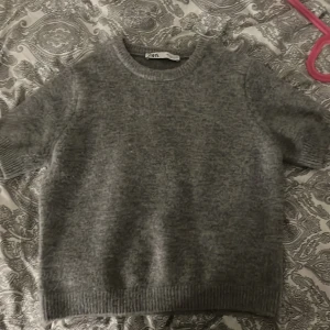 Grå stickad tröja från Zara - Mysig grå stickad tröja från Zara med korta ärmar. Xs-lite liten för mig därför jag säljer 💕