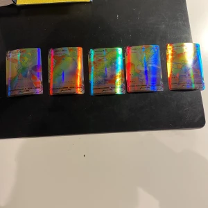 Pokémon VMAX-kort - Säljer en samling av fem Pokémon VMAX-kort med holografisk yta. Korten inkluderar populära Pokémon som Cinderace och Dragapult. Perfekt för samlare eller spelare som vill förstärka sin kortlek med kraftfulla kort.ingen frakt