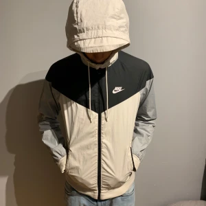 Vit, grå och svart Nike windbraker - Jag säljer min feta Nike jacka pågrund av jag inte använder den mycket längre. Storlek xs. Den är k bra skick och jag kommer se till att ha den tvättad tills köparen får den