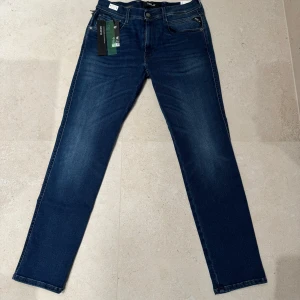 Marinblåa Replay jeans, sprillans nya. - Säljer ett par helt nya Replay-jeans för 1500 kr. Stilrena, bekväma och tillverkade i högkvalitativt material som ger en utmärkt passform. Perfekta både till vardags och för mer uppklädda tillfällen.