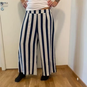Randiga byxor från H&M - Säljer ett par snygga randiga byxor från H&M i storlek 42. Byxorna är blå och vita med en loose passform . Perfekta för både vardag och fest! Väldigt stockholms stiliga
