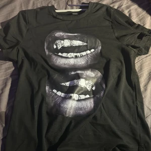 Svart T-shirt  - En svart T-shirt med munnar som tyck på framsidan🖤 Bra skick