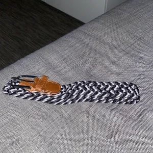 Bälte - Snyggt trendigt bälte, aldrig använd. Den är svart, grå och vit. Fin kvalite, hör av er vid frågor!