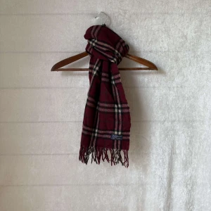 Burberry halsduk  - Säljer en klassisk rutig halsduk från Burberry burgendy röd (vinröd). Den är gjord av 100% kashmir. Perfekt för att hålla sig varm under höst och vinter. Passar både till vardags och festliga tillfällen!                 Skicket är 9/10 utan defekter👍