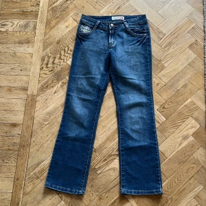 Low waist Bootcut jeans - Säljer ett par vintage bootcut jeans från Oland. De är lågmidjade och har en straight passform och är dekorerade med coola broderier på bakfickorna. Jeansen är i bra skick och perfekta för både vardag och fest. De har en knapp och dragkedja framtill samt klassiska fem fickor. Passar någon som är lite kortare.❤️❤️❤️❤️ 