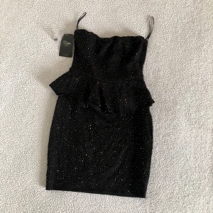 ZARA svart bandeau klänning med pärlor - Otroligt snygg bandeauklänning med peplum och pärlor från ZARA. Perfekt klänning för vinterns alla festligheter. 🎄 Ny med prislappar och extra pärlor medföljer. OBS: Dragkedjan går ej att stänga och behöver LAGAS. Därav pris.
