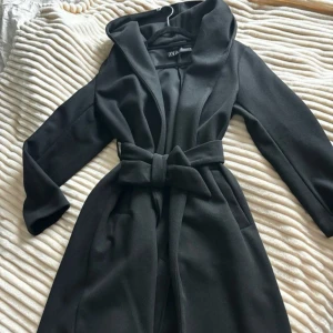 Kappa - Säljer en svart lång kappa med huva i storlek S 