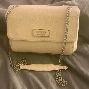 Guess väska - Super fin ljusrosa guess väska i jättebra skick. Säljer då den inte kommer till användning, skriv för fler bilder. Pris kan diskuteras! Dustbag följer med💕