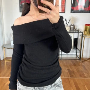 Svart offshoulder tröja Zara  - Säljer en snygg svart offshoulder tröja i ribbat material. Den har en tight passform och långa ärmar, perfekt för både vardag och fest. Tröjan är i nyskick och superbekväm att ha på sig. Passar perfekt till jeans eller kjol!